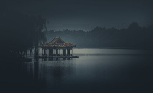 Built structure by lake against sky