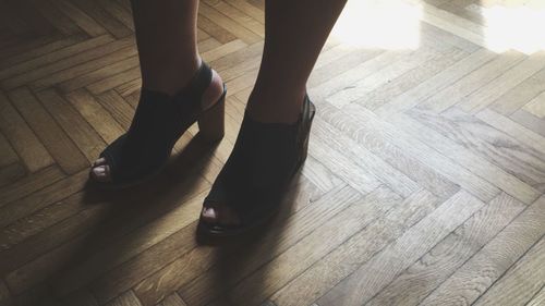 Low section of woman standing on hardwood floor