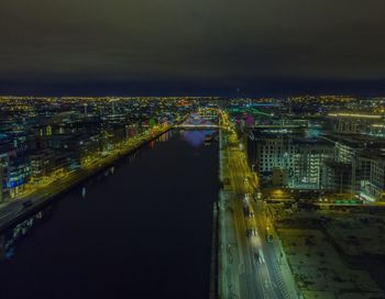 High angle view of illuminated street amidst buildings in city at night