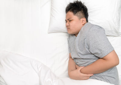 Midsection of man sleeping on bed