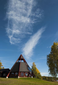 Houses by trees against sky