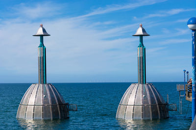 View of wooden post in sea against sky