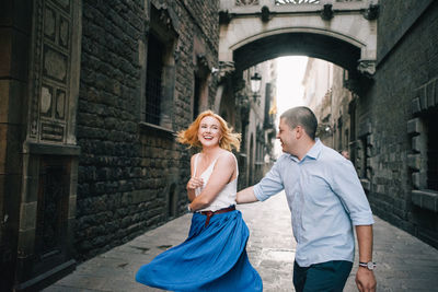 Cheerful couple dancing in alley