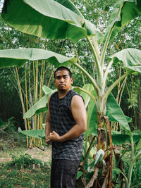 Portrait of woman standing against plants