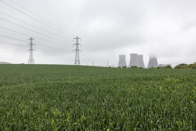 Uk, england, rugeley, field with electricity pylons and cooling towers in background