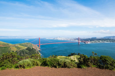 Suspension bridge over sea against sky