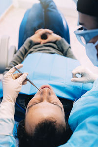 Dentist examining man in clinic