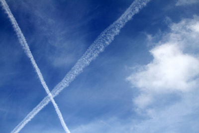 Low angle view of airplane flying against blue sky