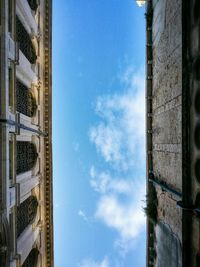 High section of skyscraper against blue sky