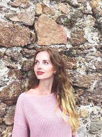 Portrait of beautiful young woman standing on rock