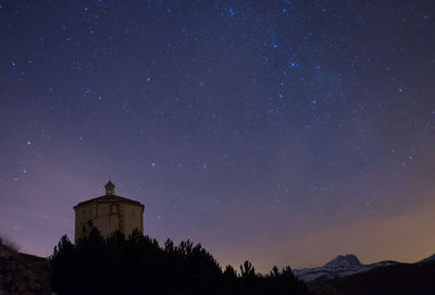 Low angle view of church against star field at night