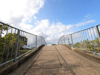 Footpath by bridge against sky in city