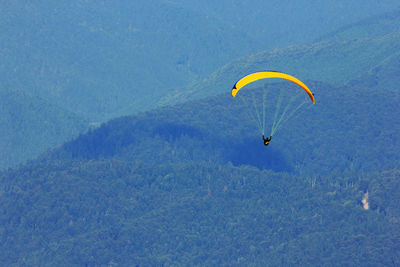 High angle view of man paragliding above mountains