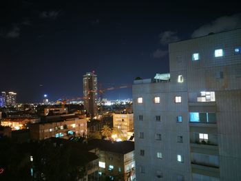 Illuminated cityscape against sky at night