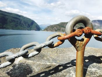 Close-up of rusty chain against sky