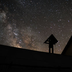 Low angle view of silhouette woman standing against star field