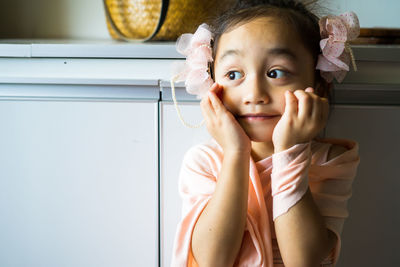 A little girl is standing in a beautiful dress with hair accessories. pretend play at home.