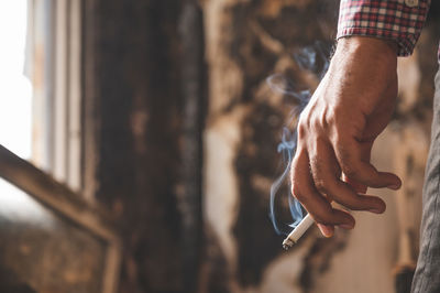 Close-up of hand holding cigarette