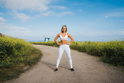 Caucasian young female standing on the path to the beach.