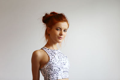 Portrait of smiling young woman against white background