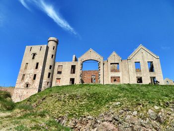 Low angle view of historic building against blue sky