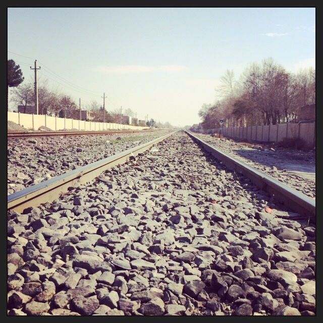 railroad track, transportation, rail transportation, the way forward, diminishing perspective, vanishing point, transfer print, tree, surface level, auto post production filter, sky, railway track, clear sky, stone - object, nature, day, outdoors, straight, tranquility, tranquil scene