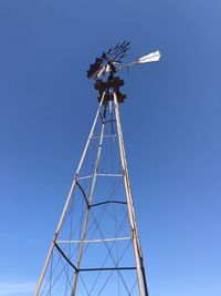 Low angle view of windmill against clear blue sky