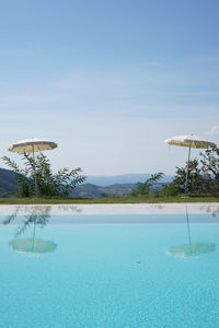 View of swimming pool by sea against sky