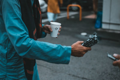 Cropped image of man holding coffee cup