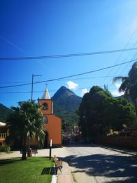 Trees and buildings against blue sky