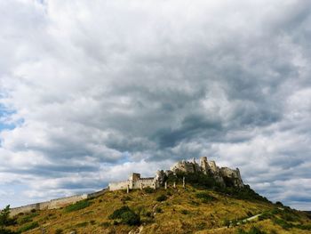Low angle view of mountain against cloudy sky