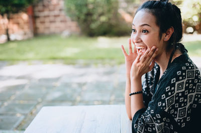 Beautiful young women positive emotion in joyful moment , hand raised near her mouth