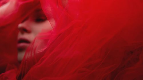 Close-up of woman amidst red textile