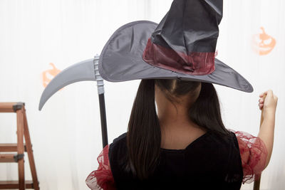 Midsection of woman holding umbrella at home