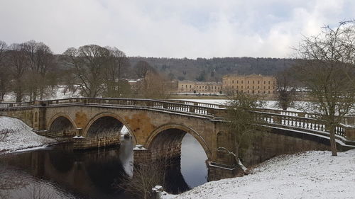 Bridge over river against sky during winter