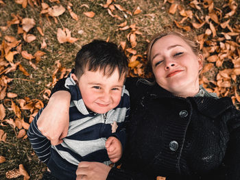 Portrait of smiling boy and mother laying on a field