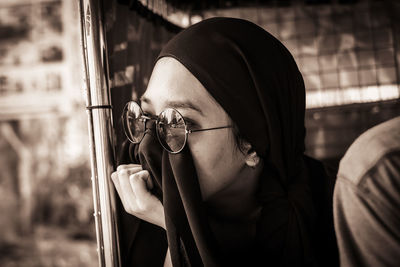 Close-up of young woman wearing hijab looking away in vehicle