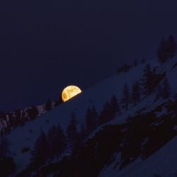 Scenic view of snowcapped mountains against sky at night