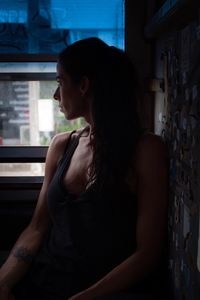 Young woman looking towards window while sitting home