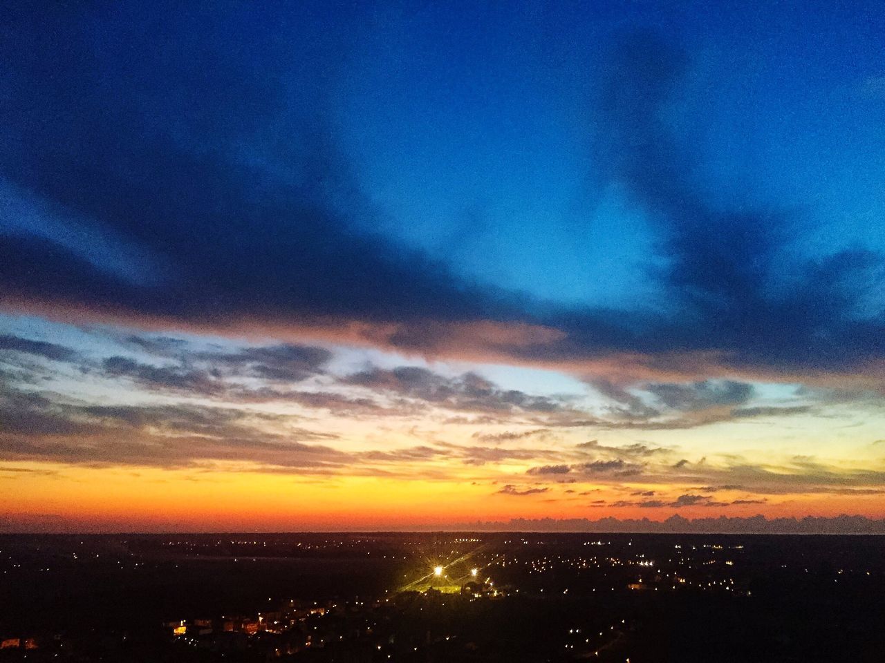 sunset, cityscape, city, orange color, scenics, sky, illuminated, vibrant color, tranquil scene, aerial view, cloud - sky, romantic sky, city life, dramatic sky, horizon over land, back lit, beauty in nature, nature, moody sky, cloud, blue, tranquility, atmosphere, outdoors, wide shot, dark, sun, majestic, wide, town, distant, multi colored