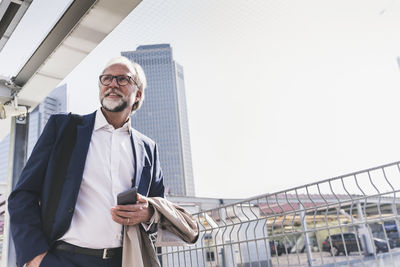 Confident mature businessman in the city looking around