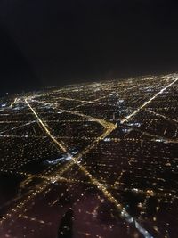 Aerial view of illuminated cityscape against sky at night