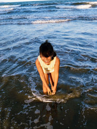 Happy girl playing in shallow water