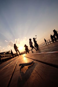 Silhouette people against sky during sunset