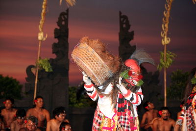 Artist in costume performing during festival at dusk