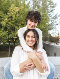 Happy lesbian women spending leisure time by wall