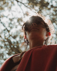 Portrait of woman against blurred trees