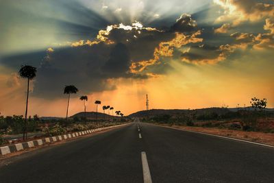 Empty road against sky during sunset