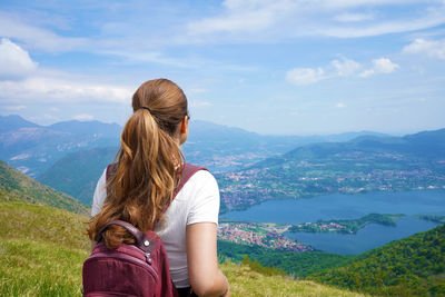 Rear view of woman looking at mountains against sky