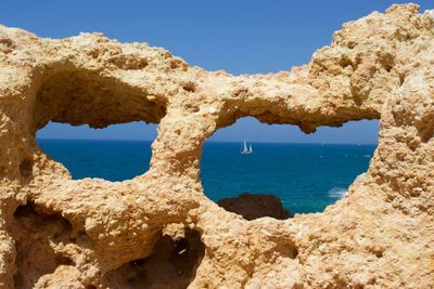 Scenic view of sea seen through rock holes on sunny day